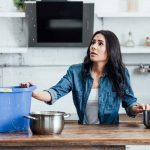 A woman is sitting at the table with her hands on her hips.