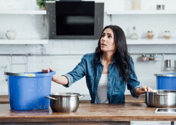 A woman is sitting at the table with her hands on her hips.