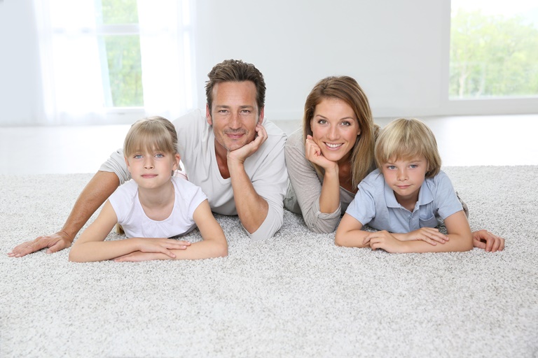 happy family of four laying on a clean carpet at home