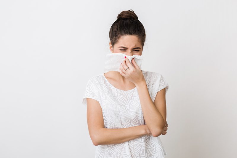 A woman with her nose covered by a napkin.