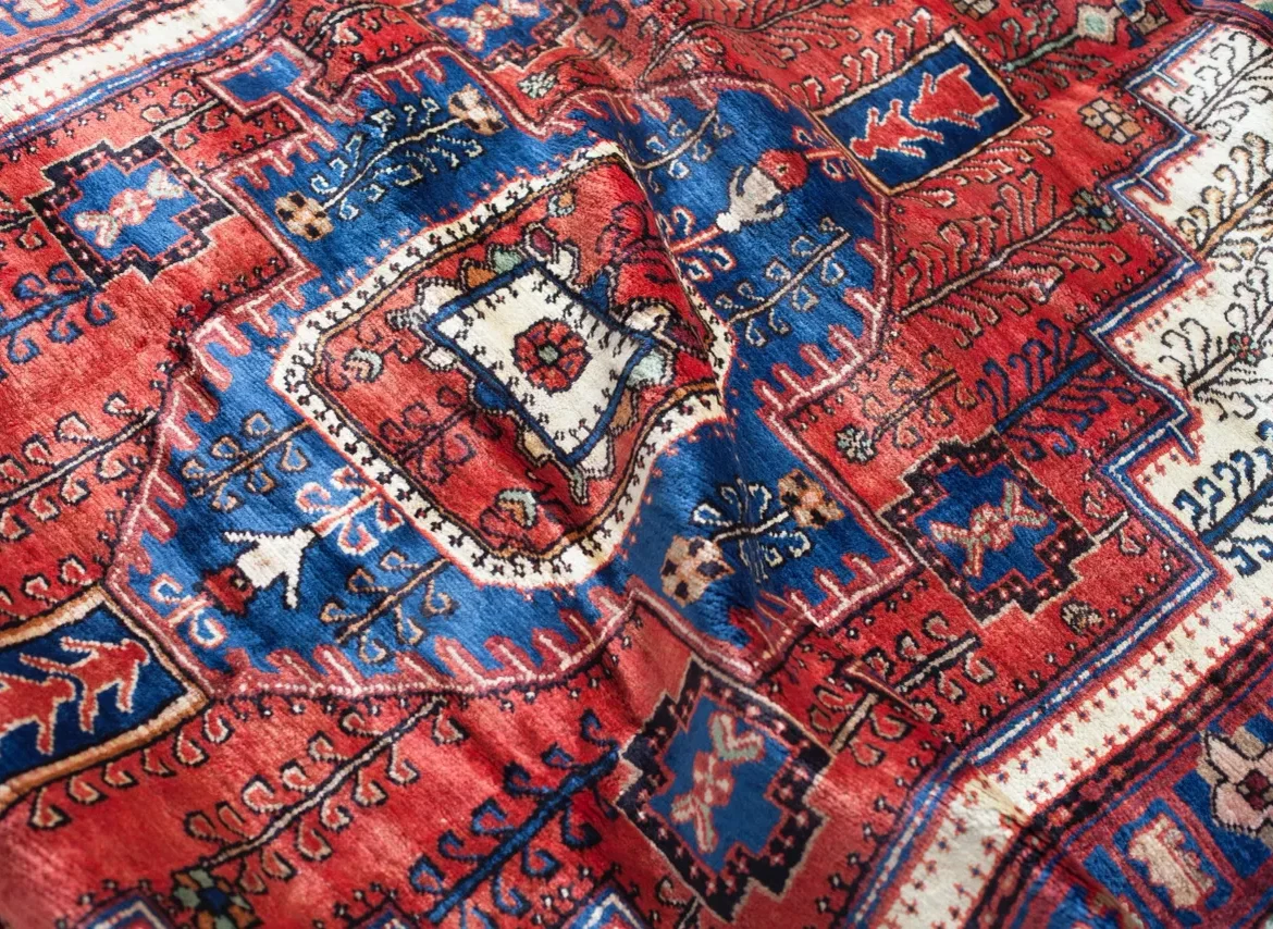A red and blue rug with designs on it.