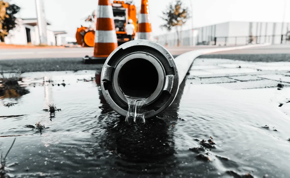A pipe laying on top of the ground in water.