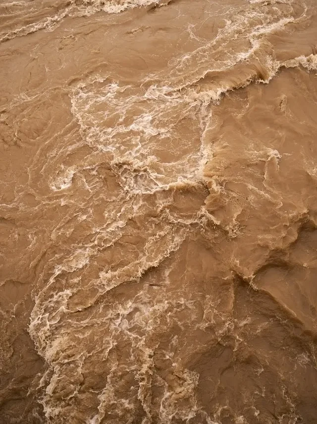 A brown water background with some waves in it