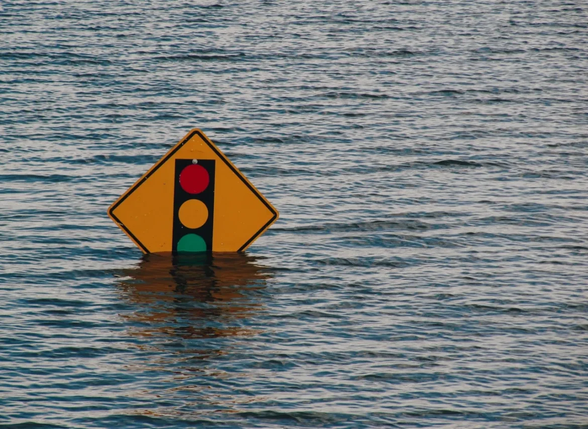 A flooded street sign in the middle of water.