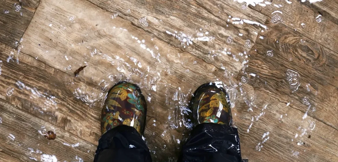 A person standing on the ground in rubber boots.