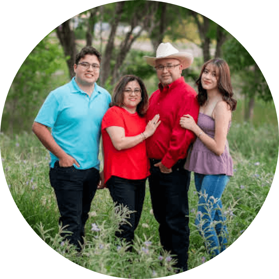 Family portrait outdoors in green field.